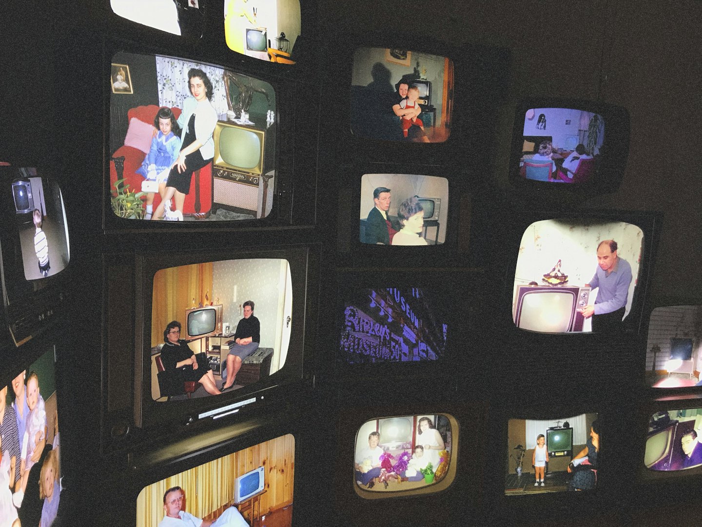 Vintage television sets displaying old family photos and scenes.