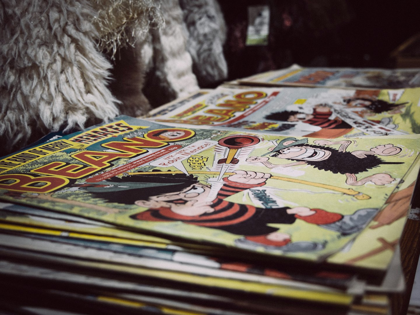 Stack of vintage comic books with a cartoon character on top.