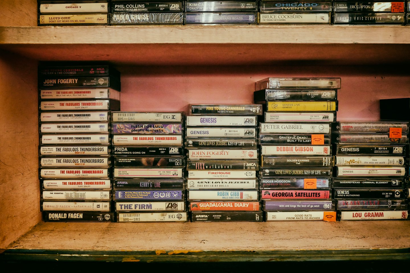 Vintage cassette tapes stacked on wooden shelves.